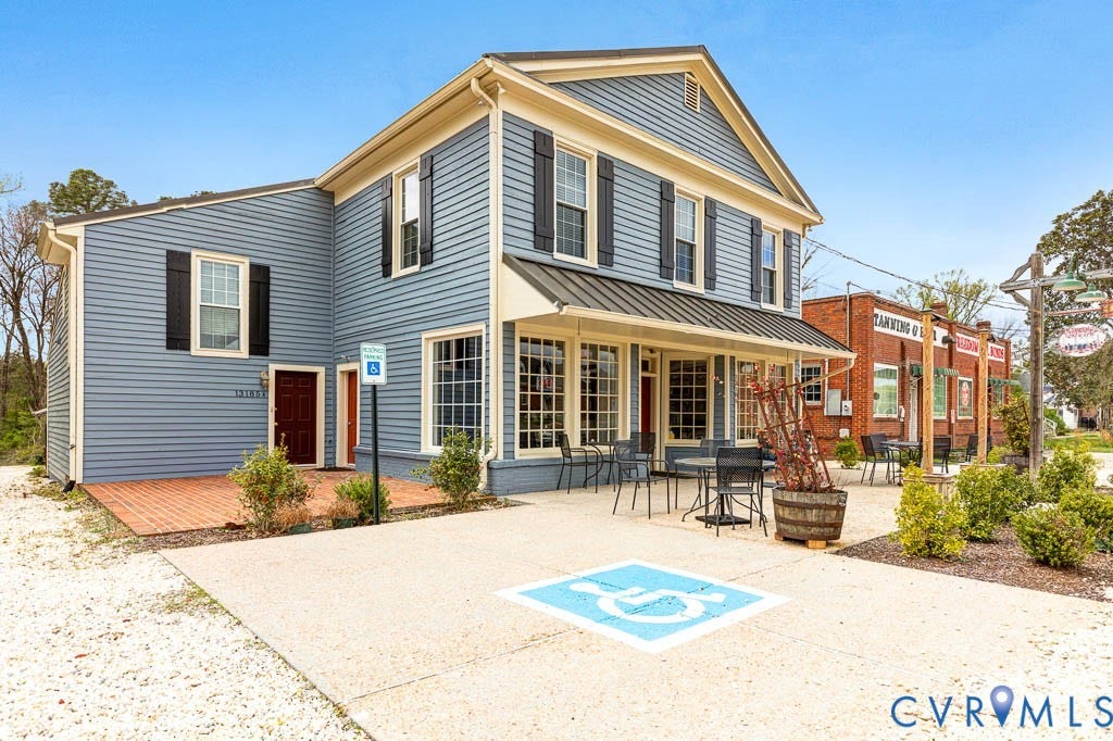 Two-story building with blue siding and black window shutters