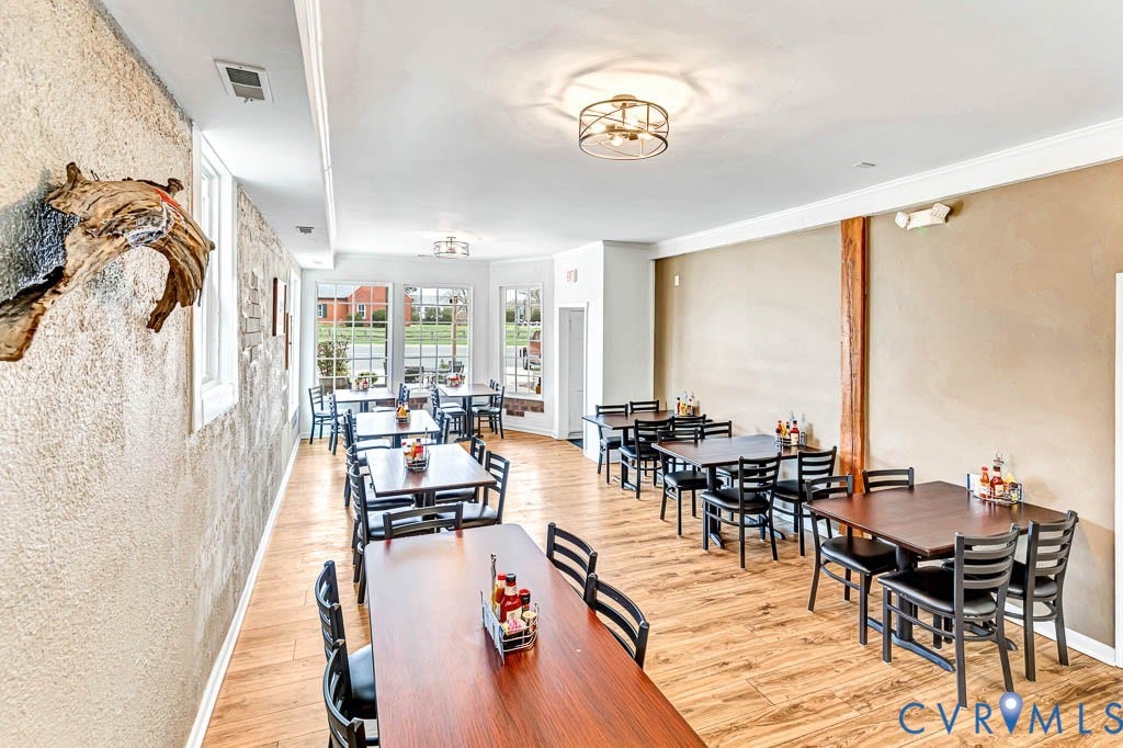 Wood-finish flooring, multiple windows, textured wall finish, recessed lighting, and crown molding