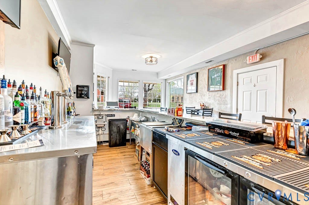 Stainless steel bar tops, wood-finish flooring, recessed lighting, and multiple windows