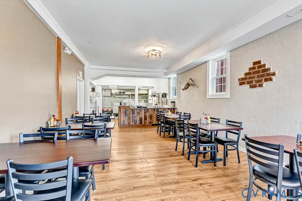 Spacious interior with wood-finish flooring, crisp white ceiling, and crown molding