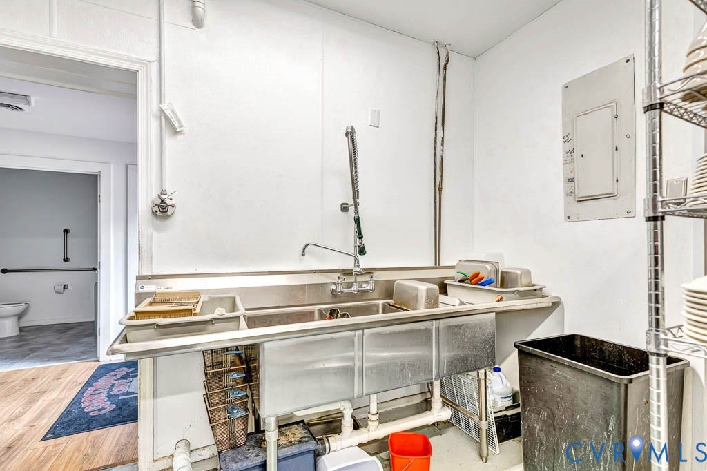 Stainless steel three-basin sink with an attached sprayer