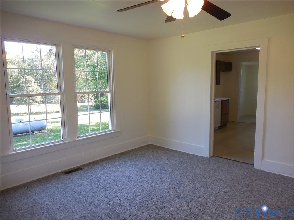 6507 Old Columbia Road, Columbia, Columbia, VA 23038 Carpeted room with white walls, two double-hung windows, and a ceiling fan with integrated lighting