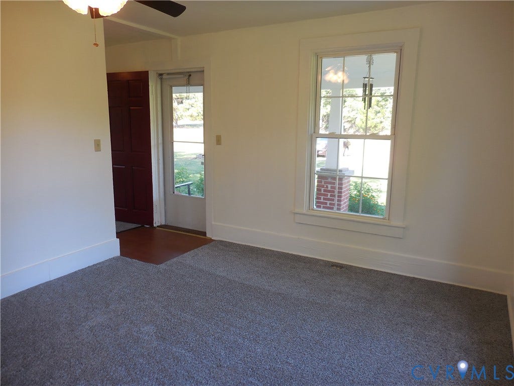 6507 Old Columbia Road, Columbia, Columbia, VA 23038 Carpeted interior space with a ceiling fan, a window with white trim, and a wood-finish flooring entrance
