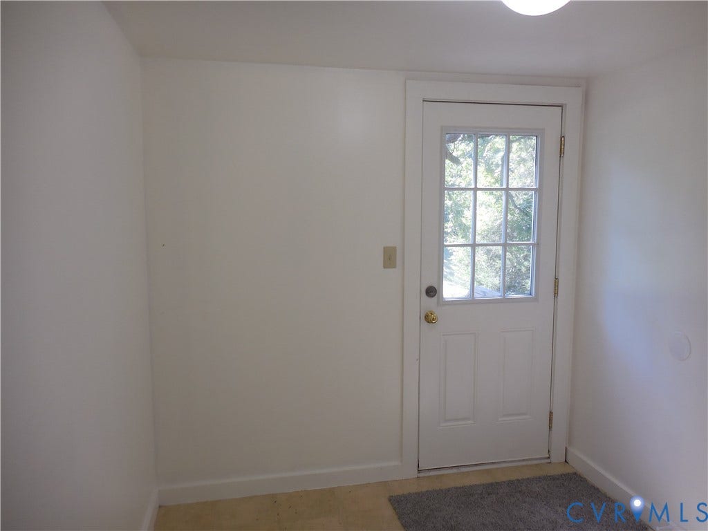 6507 Old Columbia Road, Columbia, Columbia, VA 23038 White paneled door with grid-patterned glass insert, brass knob, and light-colored trim