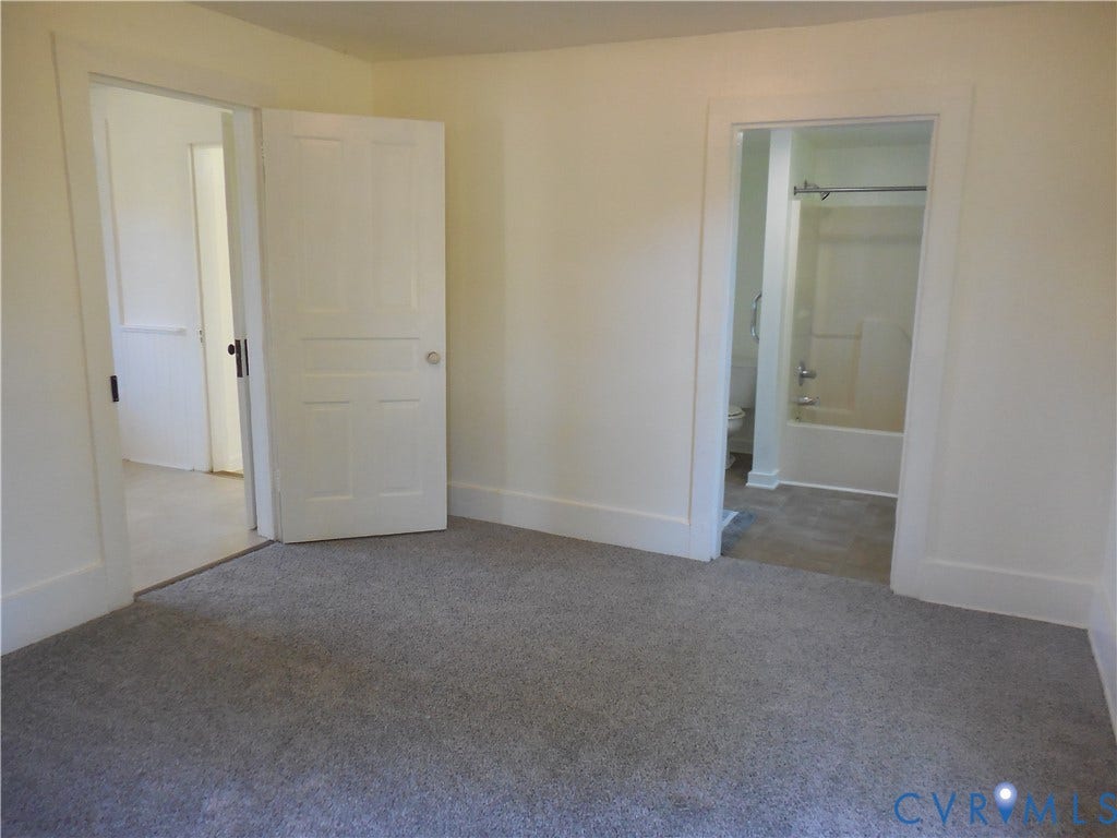 6507 Old Columbia Road, Columbia, Columbia, VA 23038 Plush carpeting with white trim, leading to a bathroom featuring a white tub and shower combination