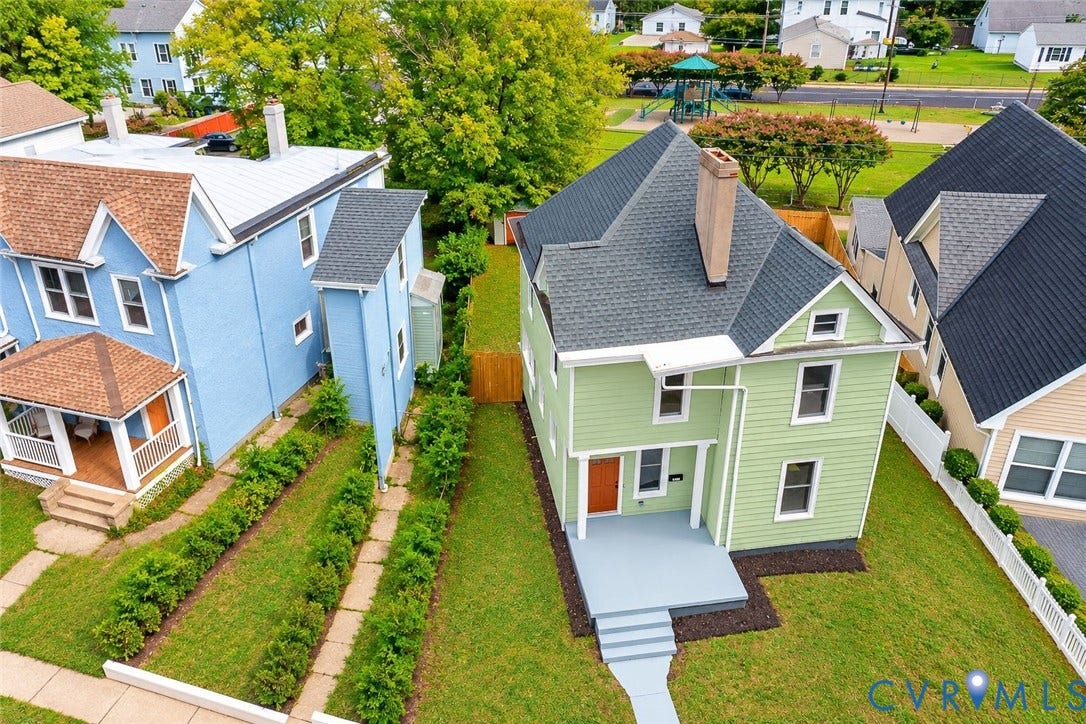 Two-story residence featuring horizontal lap siding, an asphalt shingle roof, a front porch with concrete steps, and a fenced backyard