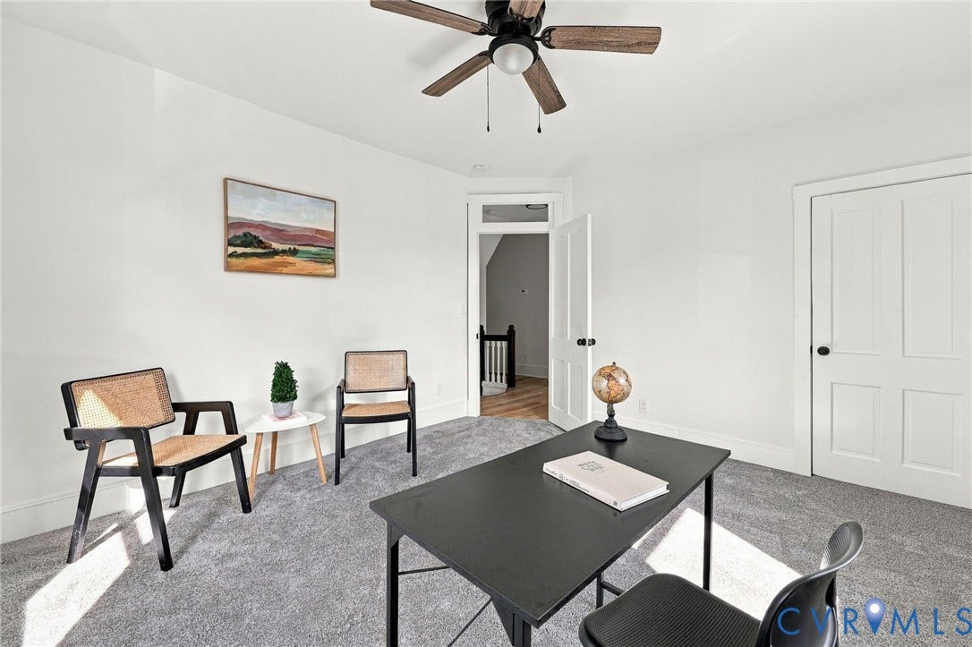 Interior room featuring neutral wall-to-wall carpeting, a ceiling fan with integrated light fixture, and a four-panel door