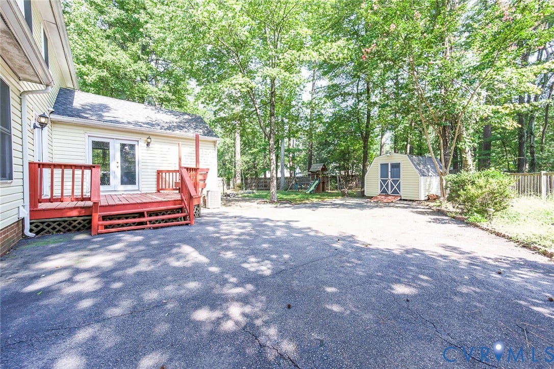4605 English Cedar Court, Glen Allen, VA 23060 Spacious rear yard featuring a paved drive, a detached shed, a red-stained wood deck, and double-pane glass doors