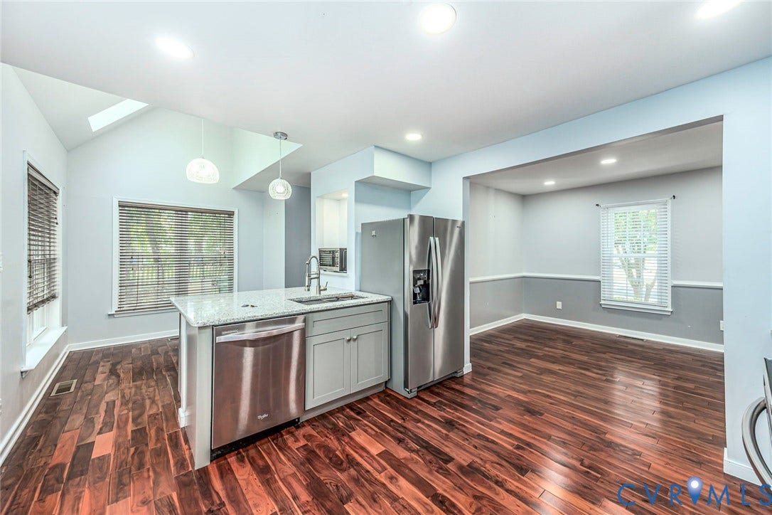 4605 English Cedar Court, Glen Allen, VA 23060 Kitchen featuring an island with a stainless steel sink, light-toned cabinetry, and a granite countertop