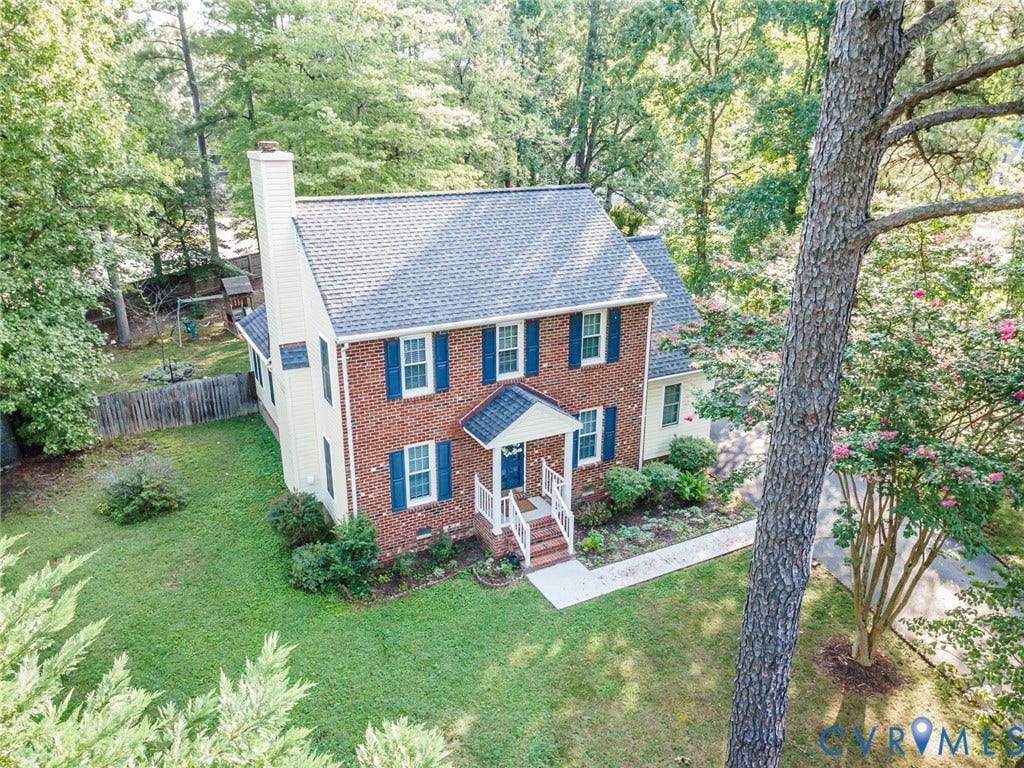 4605 English Cedar Court, Glen Allen, VA 23060 Brick and siding exterior with blue shutters, a front entry porch, a paved driveway, and established trees and shrubs