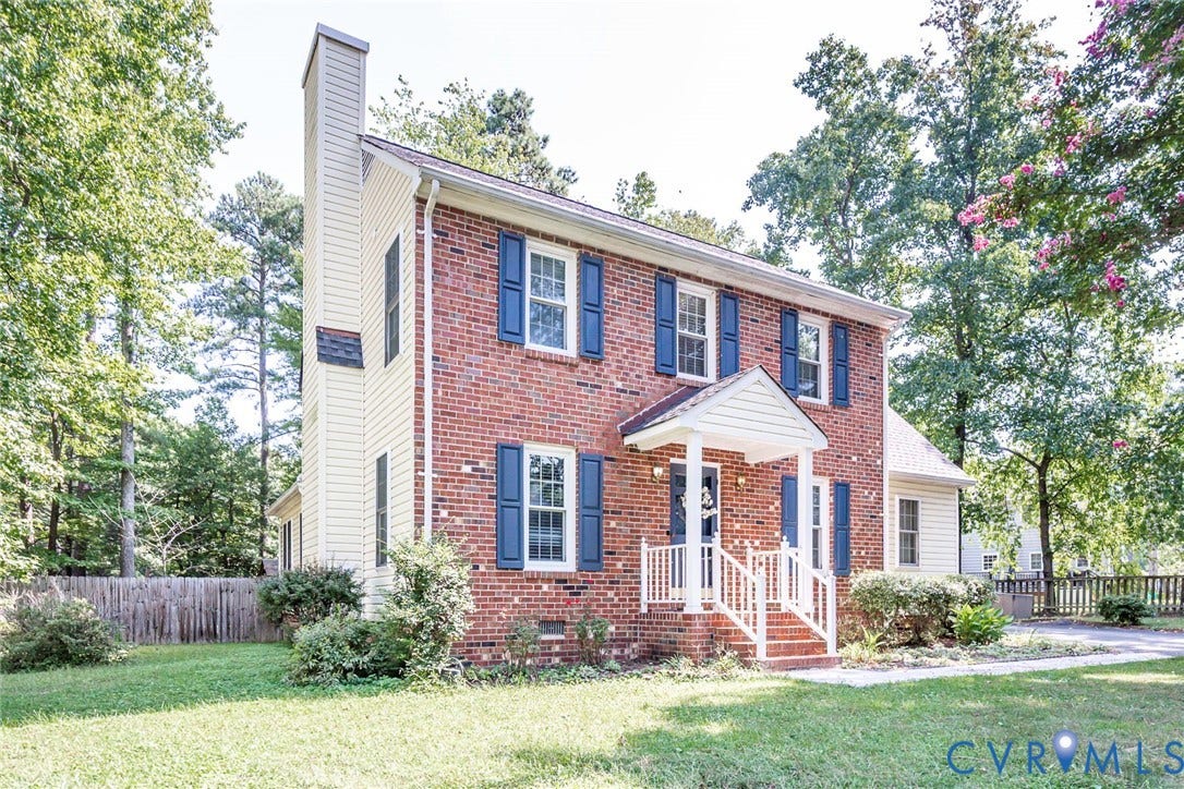 4605 English Cedar Court, Glen Allen, VA 23060 Brick exterior with a covered entry, white porch railings, matching blue window shutters, and a prominent chimney