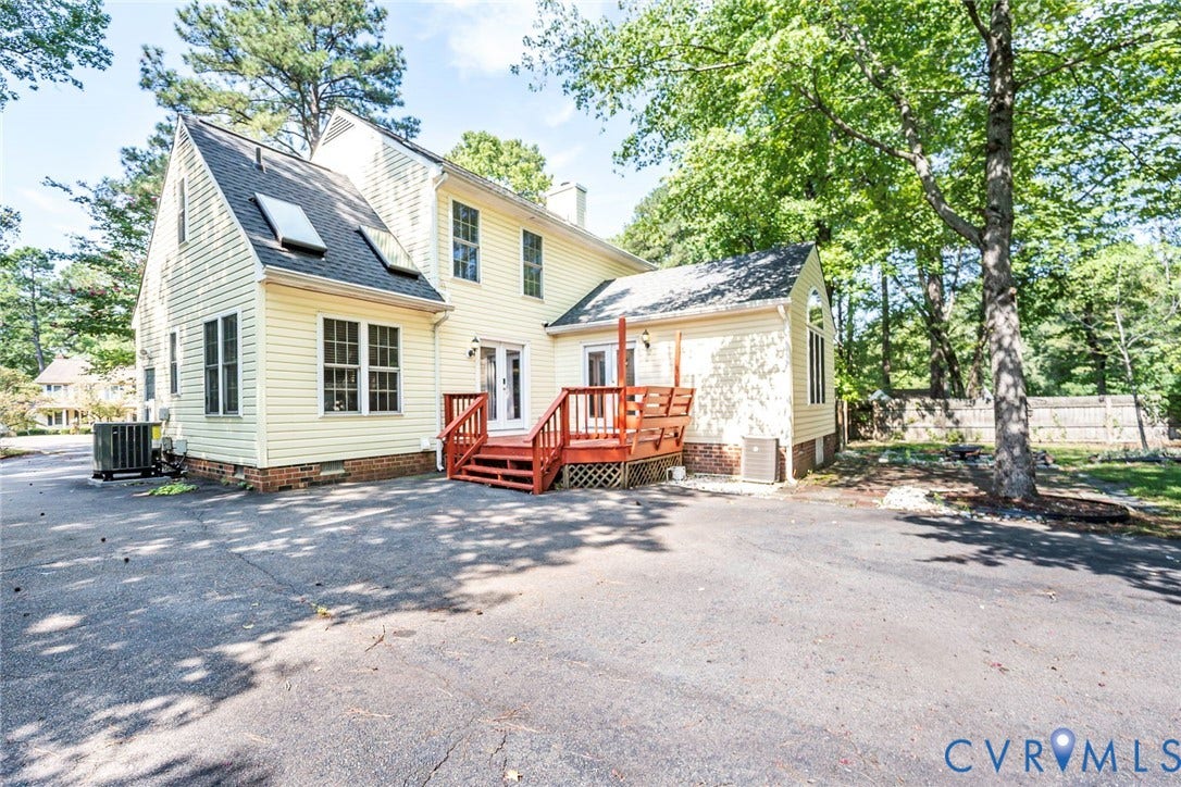 4605 English Cedar Court, Glen Allen, VA 23060 Yellow siding exterior featuring a red wood deck, double glass panel doors, and skylights