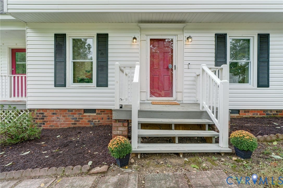 14 Redbridge Terrace, Shendoah Hills, Chesterfield, VA 23236 White vinyl siding exterior with a red front door, leading to a wooden porch with white railings and steps