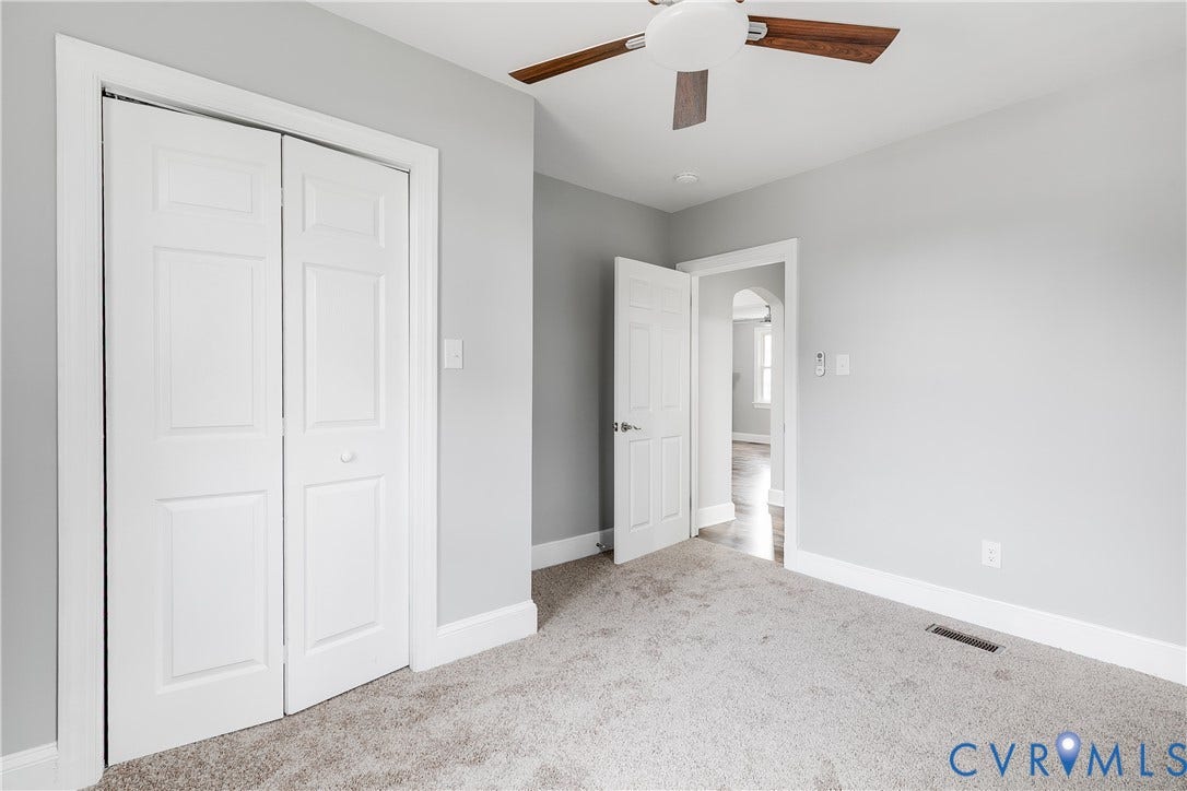 2012 Bailey Avenue, Richmond, VA 23231 Neutral tone wall paint, light-colored carpet, white trim, paneled bifold closet doors, and a ceiling fan with wood-finish blades