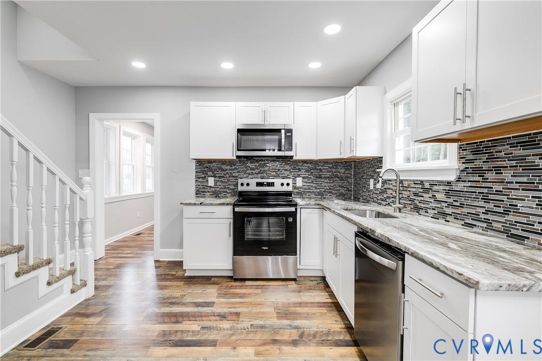 2012 Bailey Avenue, Richmond, VA 23231 Updated kitchen featuring white shaker cabinetry, stainless steel appliances, a multi-tone tile backsplash, and light-toned countertops