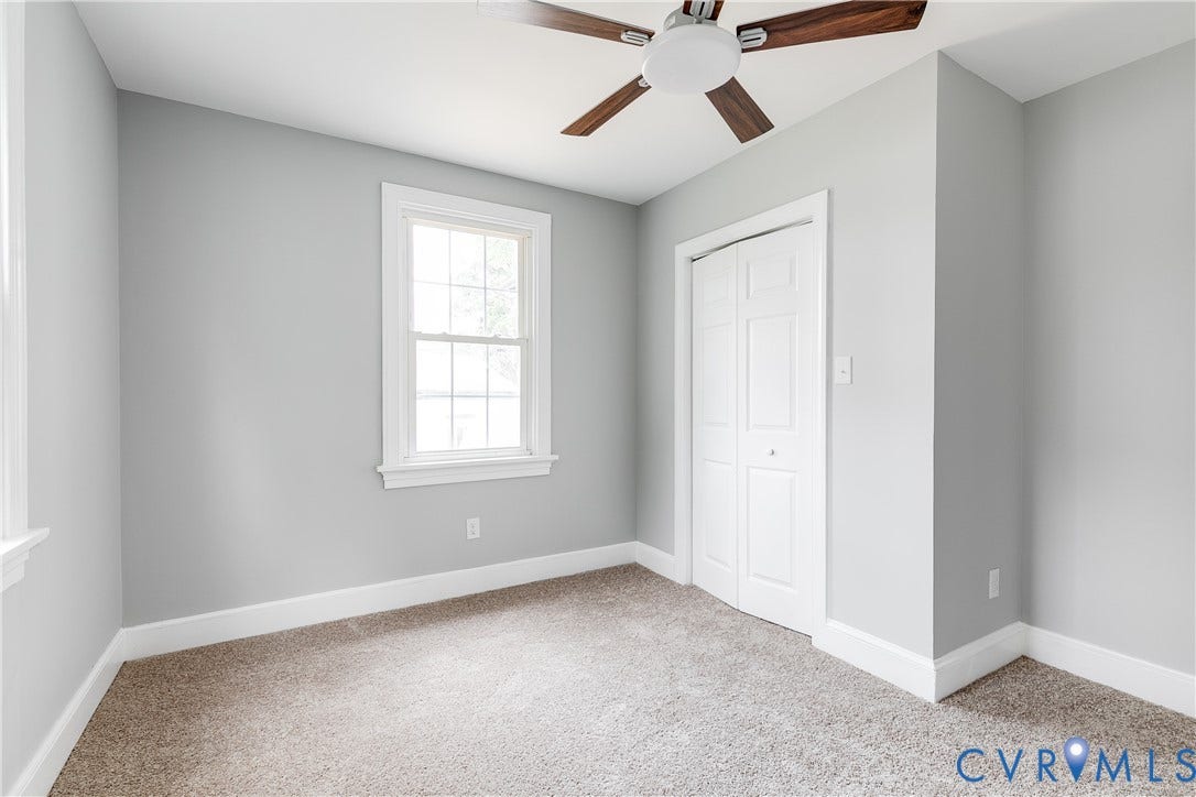 2012 Bailey Avenue, Richmond, VA 23231 Neutral tone walls, carpeted flooring, a ceiling fan with wood-finish blades, a double-hung window, and bi-fold closet doors