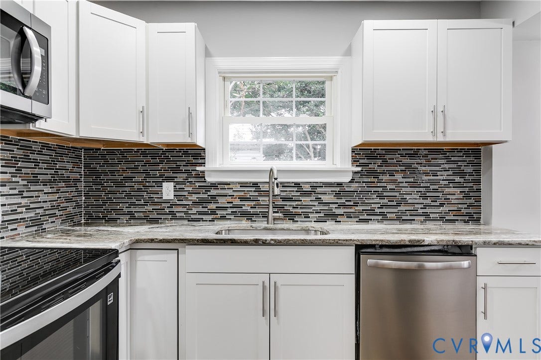 2012 Bailey Avenue, Richmond, VA 23231 White cabinetry with brushed nickel hardware, variegated tile backsplash, light-toned countertop, stainless steel sink with a gooseneck faucet, and stainless steel dishwasher