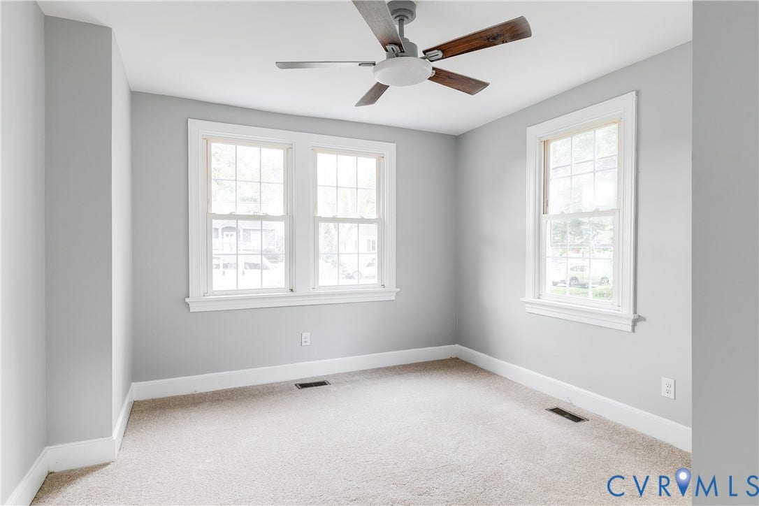 2012 Bailey Avenue, Richmond, VA 23231 Light gray painted walls with white trim, two multi-pane windows, and a ceiling fan with wood-finish blades