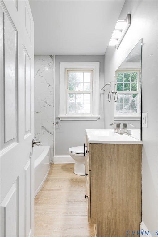 2012 Bailey Avenue, Richmond, VA 23231 Bathroom featuring a wood-finish vanity with white countertop, chrome faucet, wall-mounted mirror, and wood-finish flooring