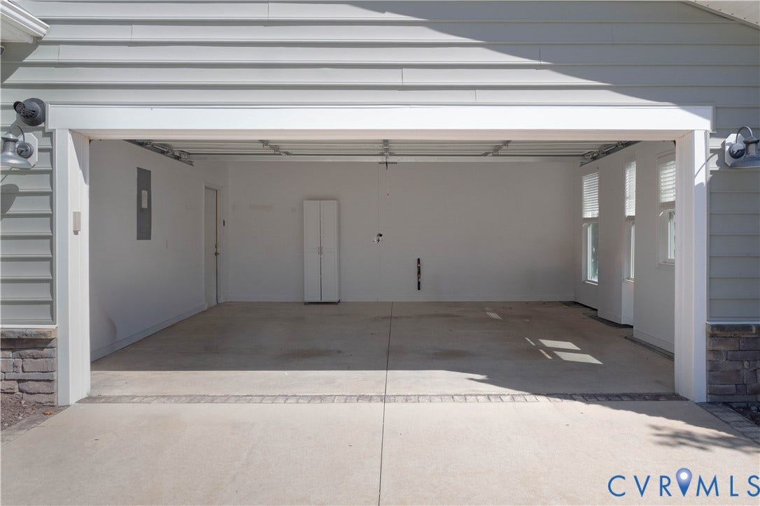 Spacious garage with multiple windows, built-in storage cabinet, and a side access door