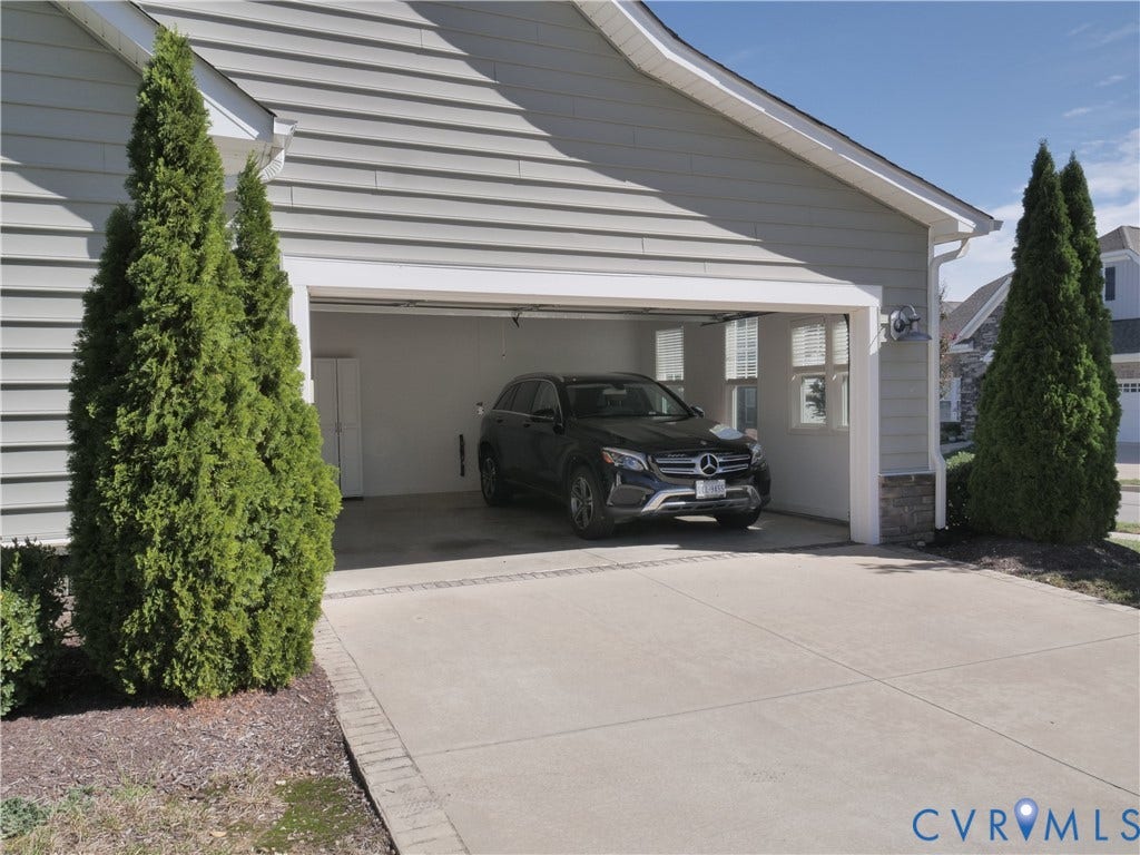Attached two-car garage with a concrete driveway and brick edging