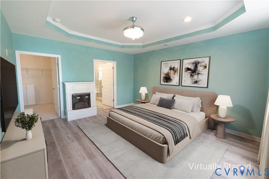 Tray ceiling with crown molding, wood-finish flooring, built-in electric fireplace, recessed lighting, and ceiling fan with light fixture
