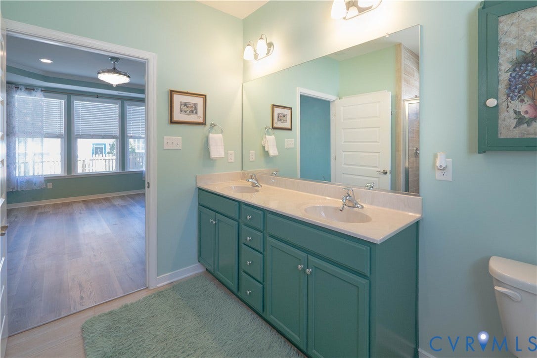 Double vanity with dual sinks and ample countertop space, complemented by a large wall-mounted mirror