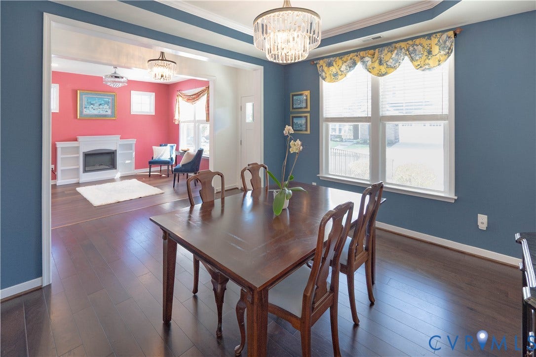 Hardwood flooring, tray ceiling, recessed lighting, and a chandelier in the dining area