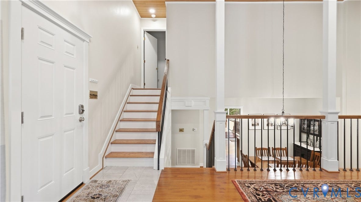 2203 Rockwater Terrace, Henrico, VA 23238 Two-story foyer with hardwood flooring, a white paneled entry door, and a staircase with wood treads and wrought iron balusters