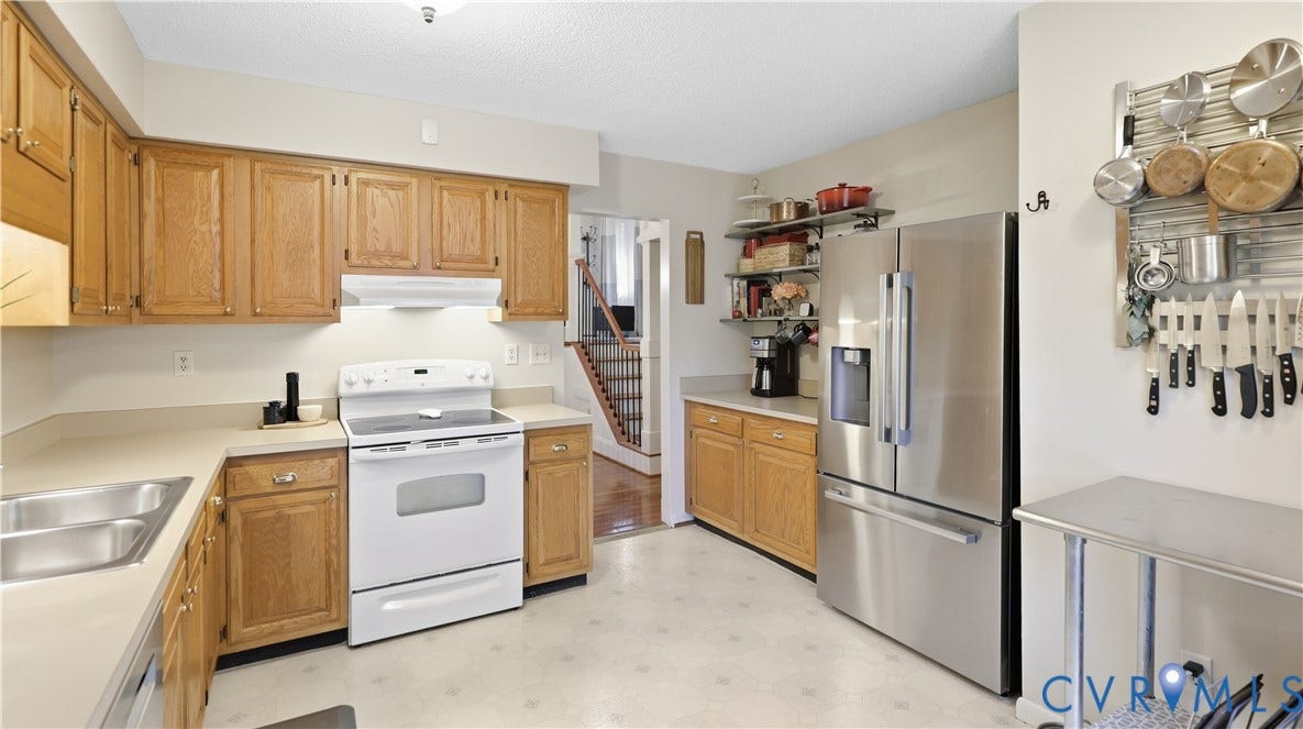 2203 Rockwater Terrace, Henrico, VA 23238 Kitchen featuring wood cabinetry, solid surface countertops, double basin sink, and a stainless steel refrigerator