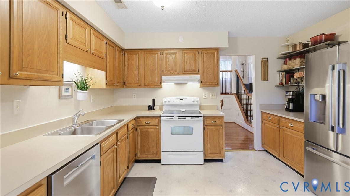 2203 Rockwater Terrace, Henrico, VA 23238 Kitchen featuring wood-finish cabinetry, light countertops, stainless steel double basin sink, and stainless steel dishwasher