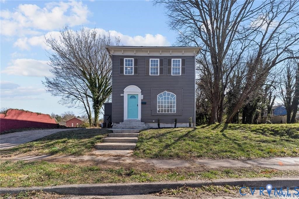 924 Lee Avenue, Poorhouse Plat, Petersburg, VA 23803 Two-story exterior with gray siding, contrasting white trim, and a vibrant blue entry door