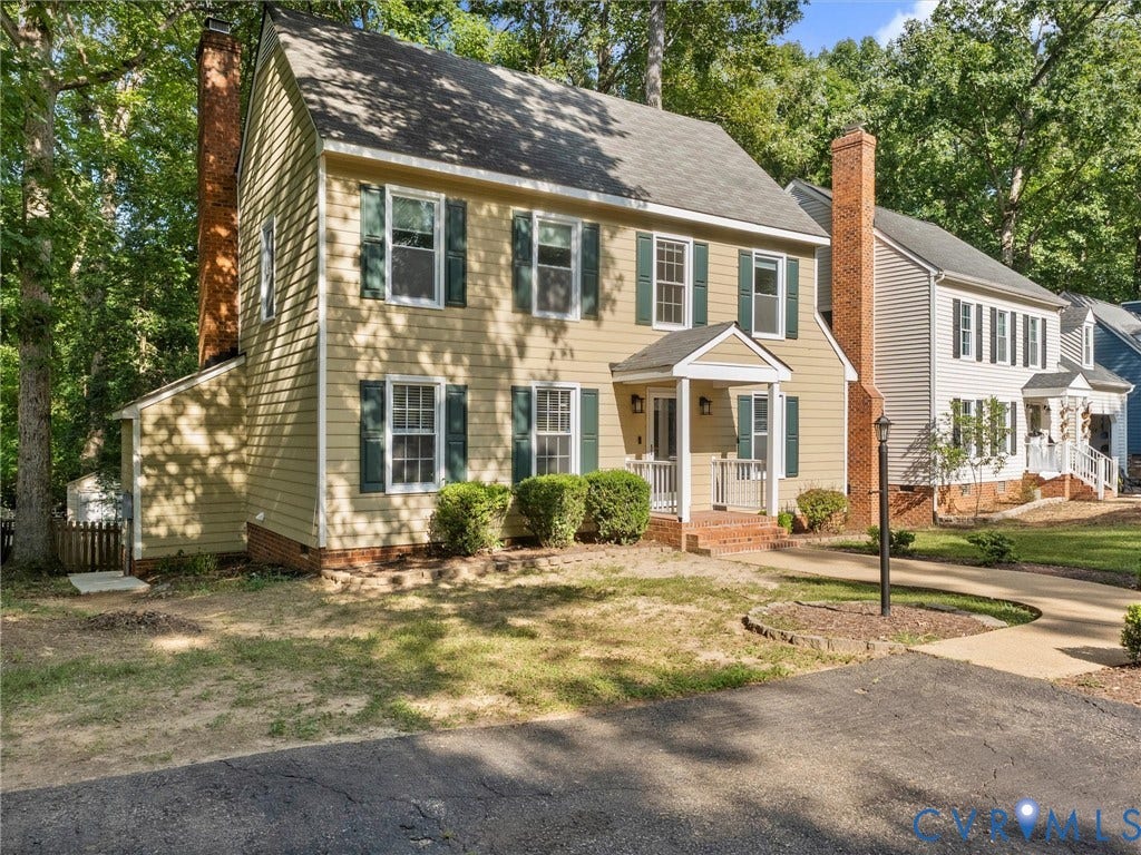 Two-story residence featuring light-colored siding and a covered front porch