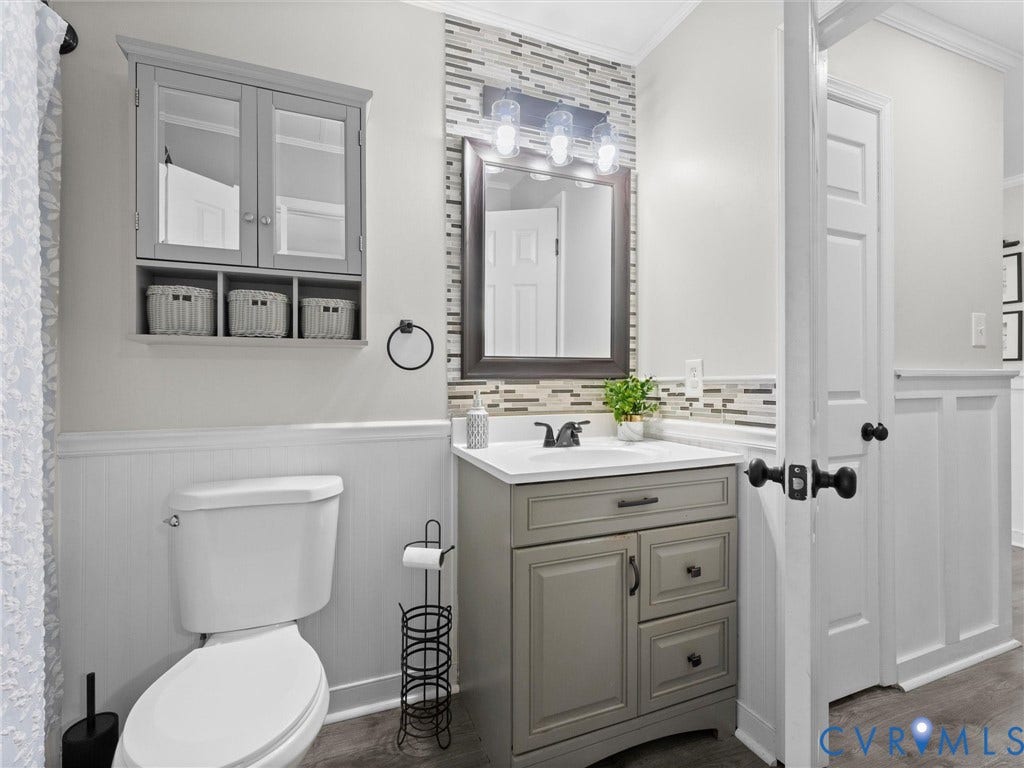 Vanity with white countertop, undermount sink, and dark hardware