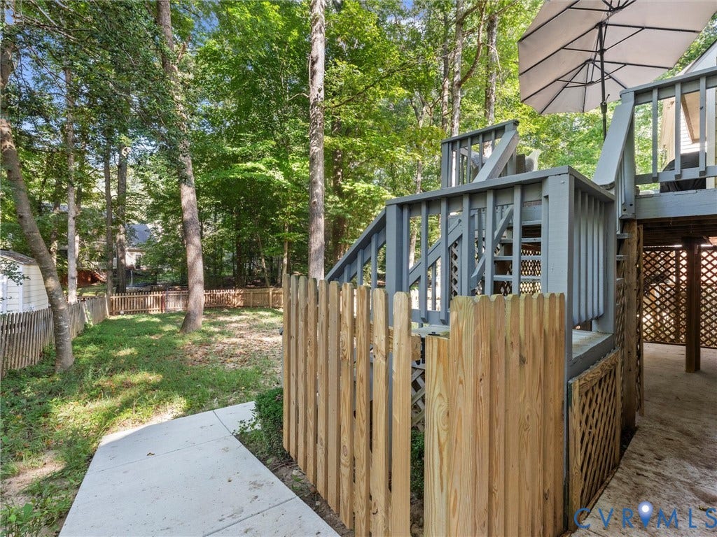 Multi-level exterior deck with painted wood construction, wood lattice skirting, and a private wood fence