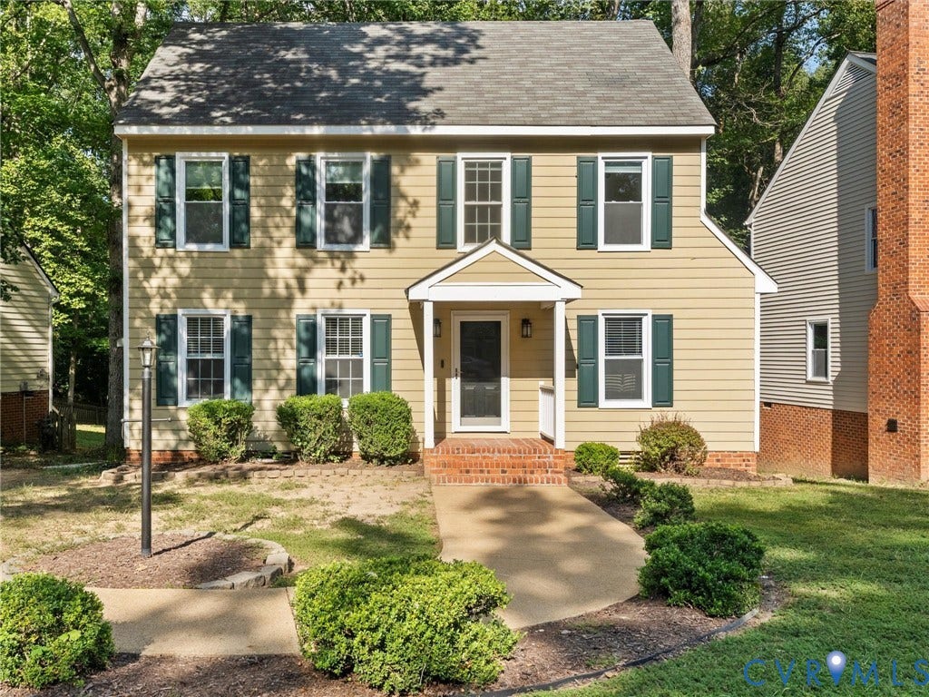 Two-story property featuring light-toned siding and a covered front entry