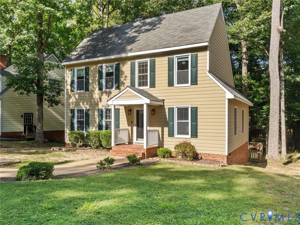 Two-story residence featuring light-colored siding and a covered front porch with white railings
