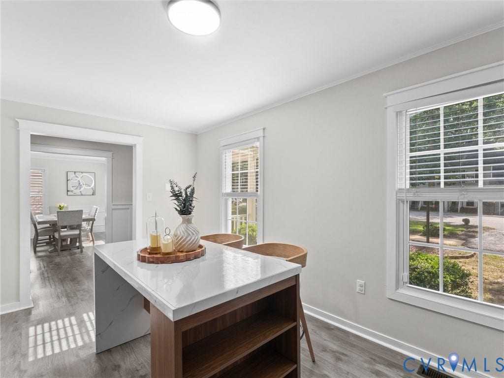 Kitchen island with a waterfall countertop, open shelving, and wood-finish flooring