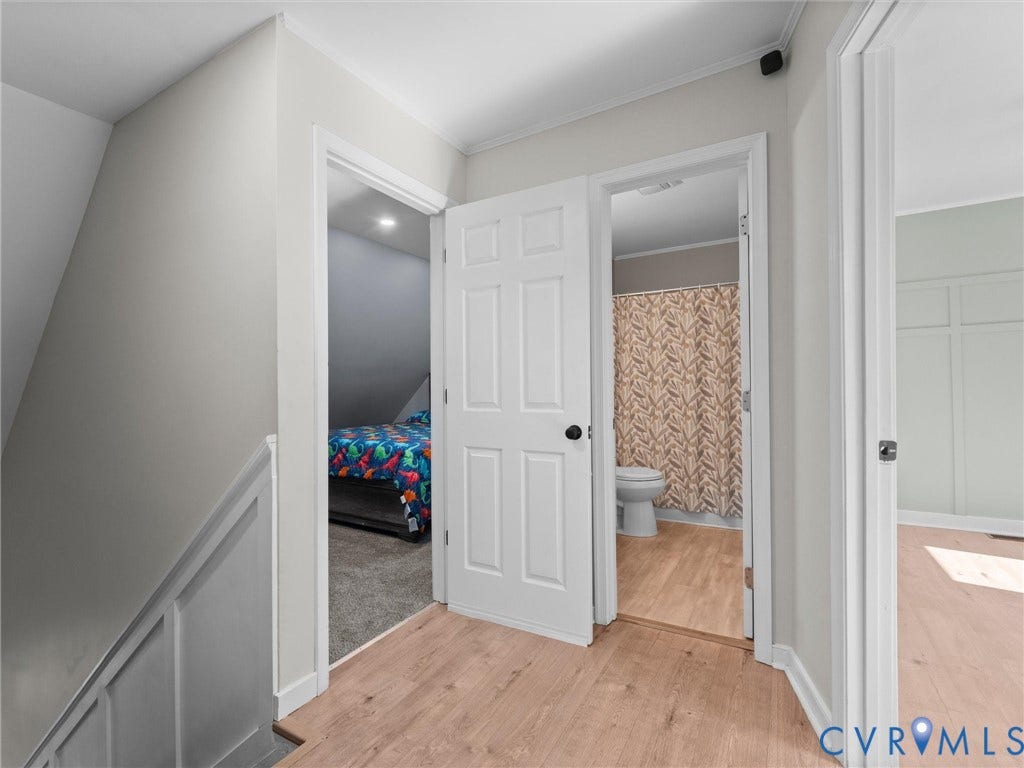 Wood-finish flooring throughout, white paneled doors, and light gray wall paint