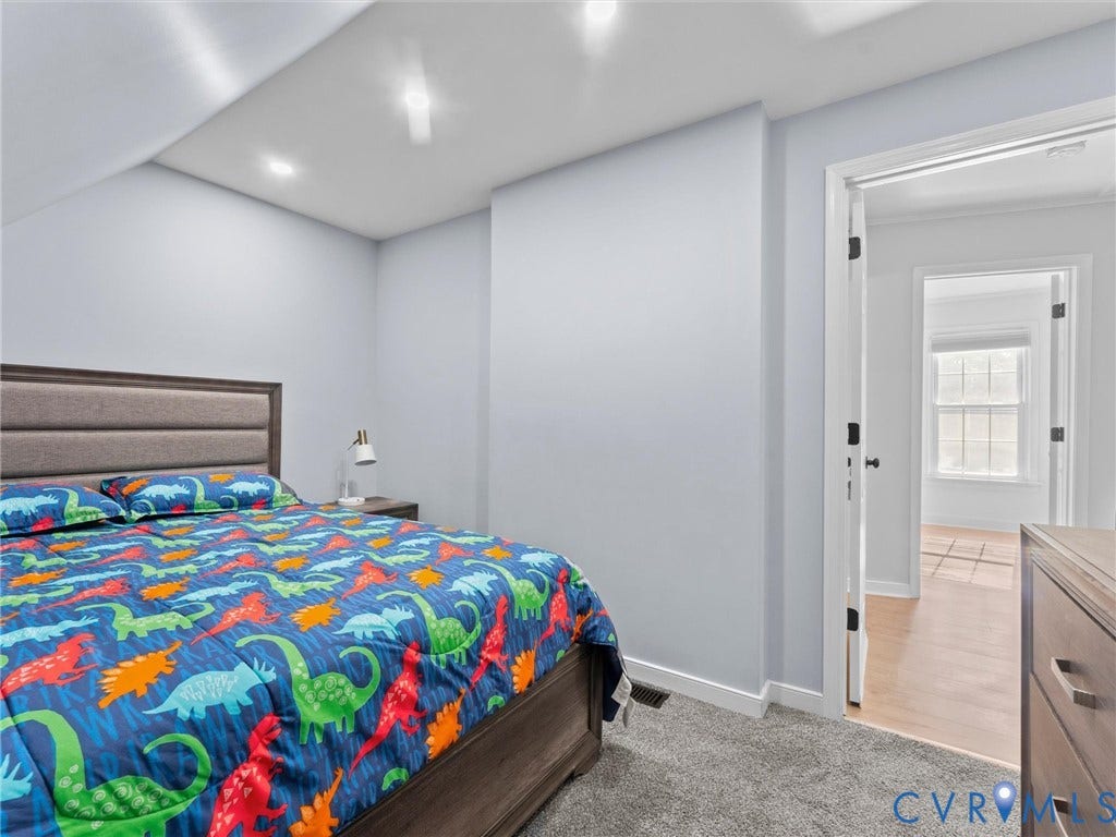 Recessed lighting, wood-finish flooring, and soft gray carpeting
