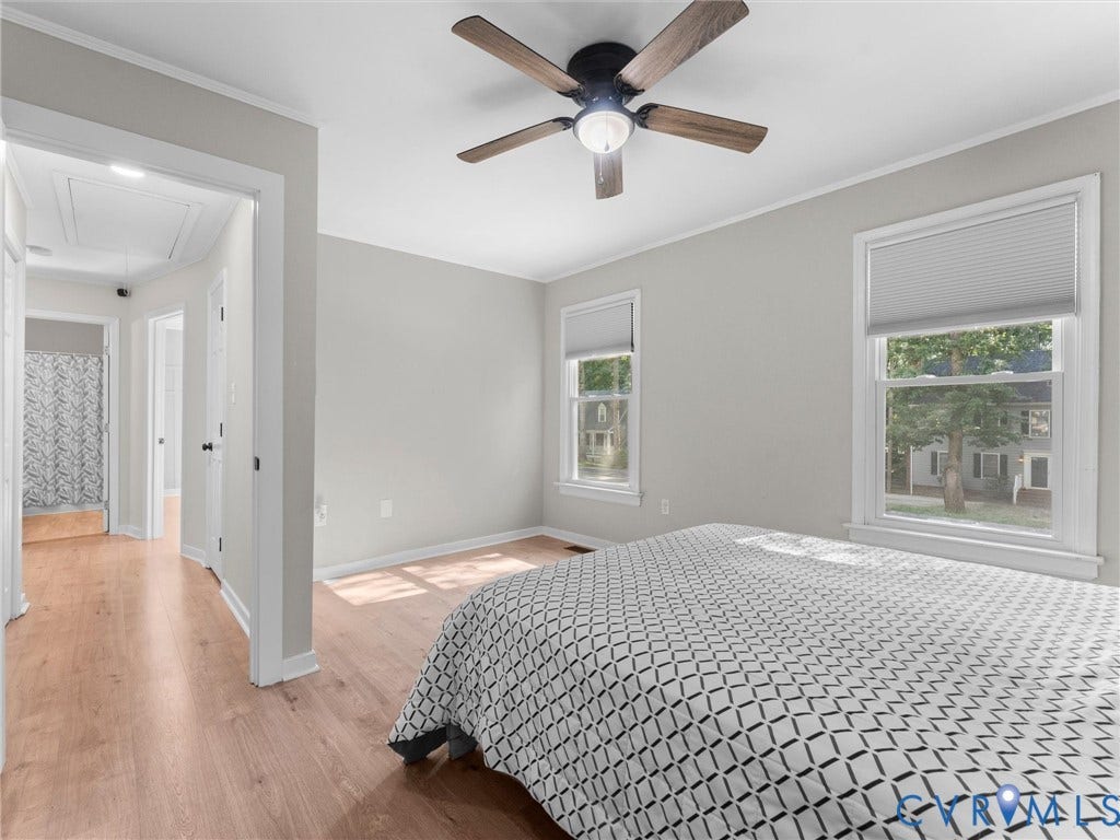 Wood-finish flooring, ceiling fan with integrated lighting, and multiple windows