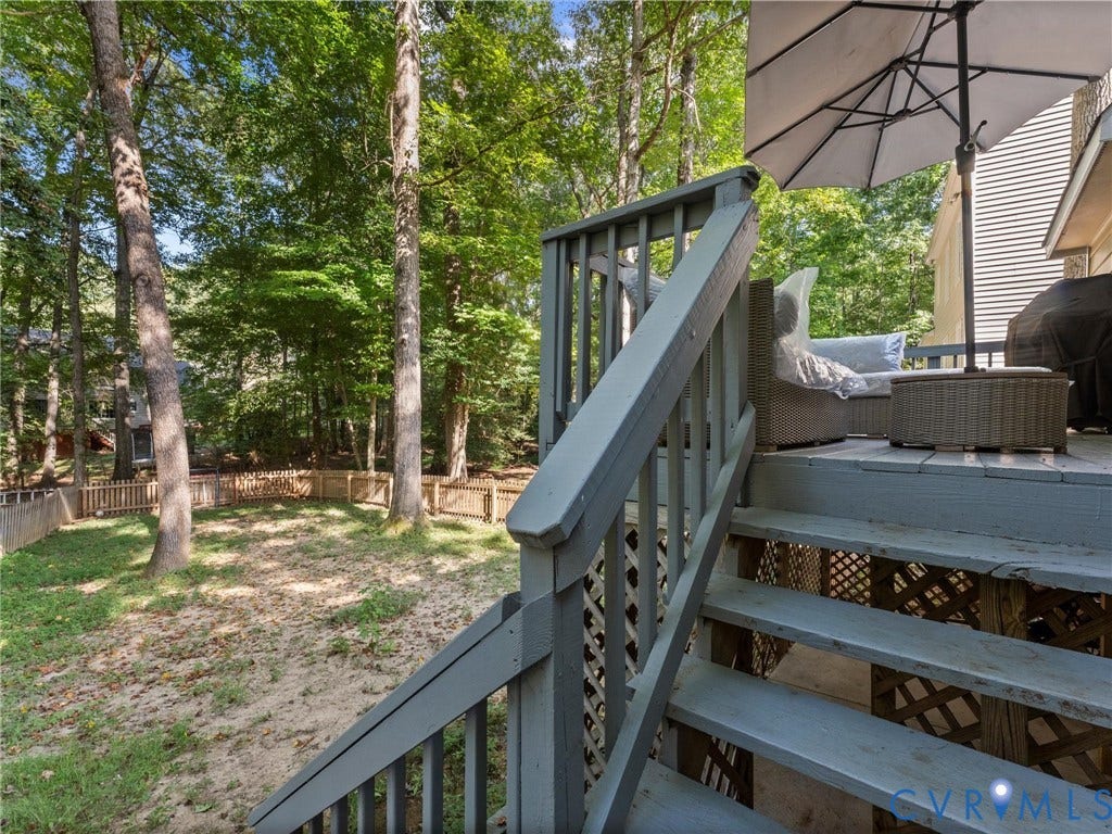 Wood deck featuring a lattice skirt, a wood railing, and stairs