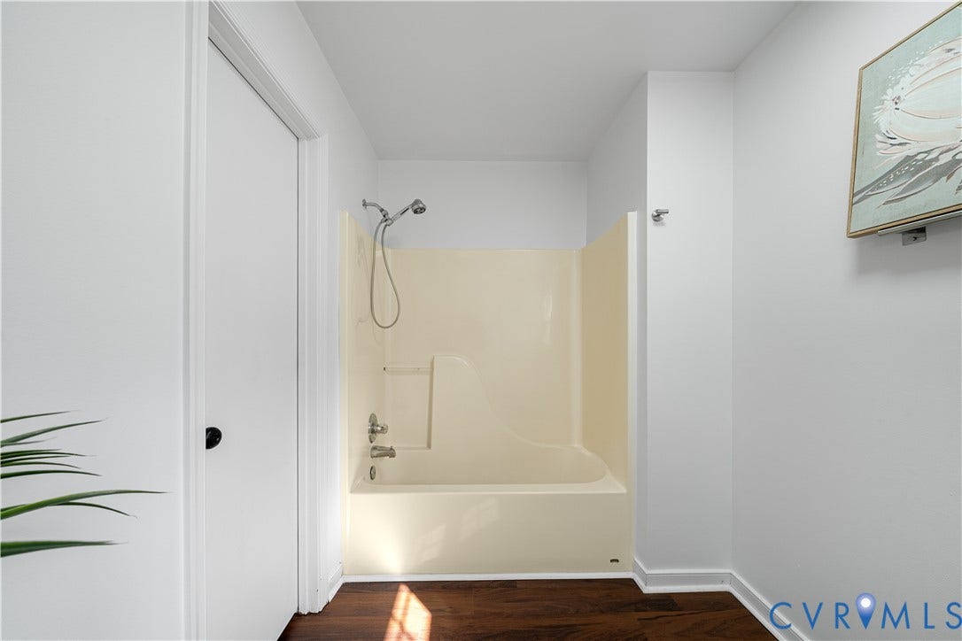 8414 Whirlaway Drive, Matoaca, Midlothian, VA 23112 Bathtub and shower combination with a flexible showerhead, dark wood-finish flooring, and white painted walls