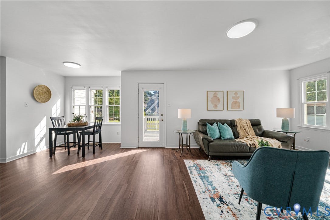 8414 Whirlaway Drive, Matoaca, Midlothian, VA 23112 Open-concept living area featuring wood-finish flooring, white walls, multiple windows, and a glass-paneled door