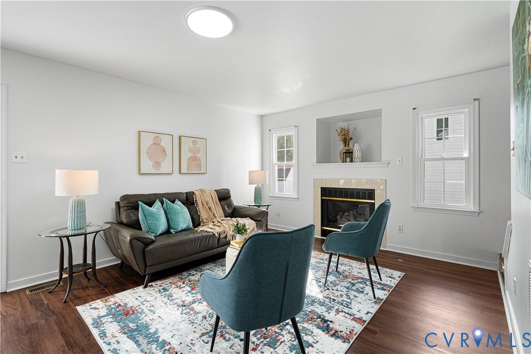 8414 Whirlaway Drive, Matoaca, Midlothian, VA 23112 Living area featuring wood-finish flooring, white walls, a built-in fireplace with a hearth, and multiple windows