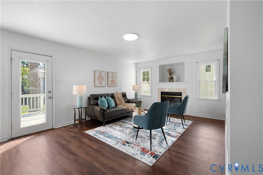 8414 Whirlaway Drive, Matoaca, Midlothian, VA 23112 Wood-finish flooring, white walls, built-in fireplace with mantel, recessed wall alcoves, and a glass-paneled door to an exterior deck