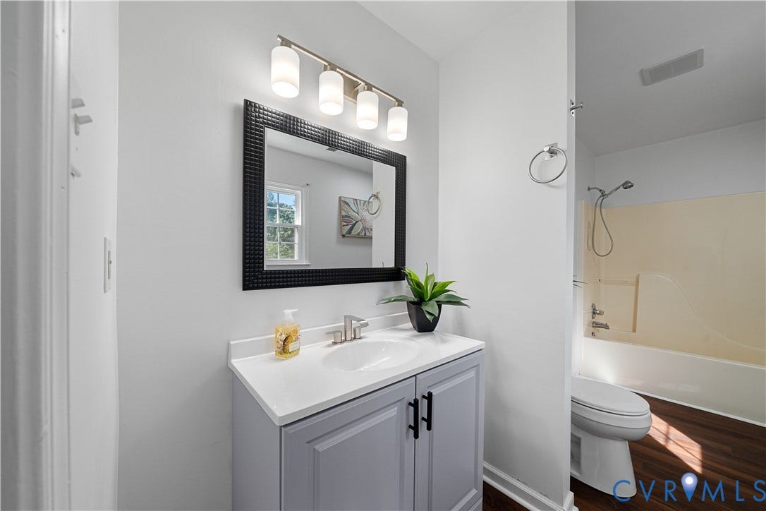 8414 Whirlaway Drive, Matoaca, Midlothian, VA 23112 Vanity with white countertop and integrated sink, framed mirror, and chrome light fixture