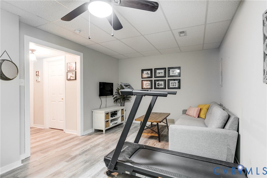 Versatile finished room featuring wood-finish LVP flooring, recessed lighting, a ceiling fan, and crisp white trim