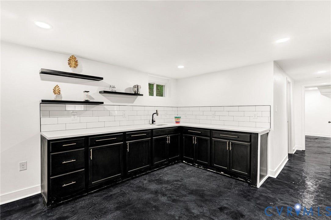 503 Pollock Street, Richmond, VA 23222 L-shaped cabinetry with dark finishes, integrated sink, and wall-mounted faucet