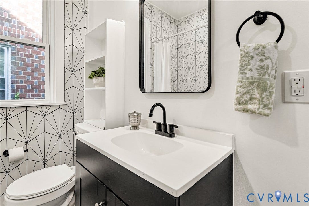 503 Pollock Street, Richmond, VA 23222 Modern vanity with an integrated white sink and black hardware, complemented by a contemporary framed mirror